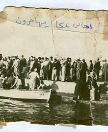 image of old photograph of crowd of people standing near boats on a river